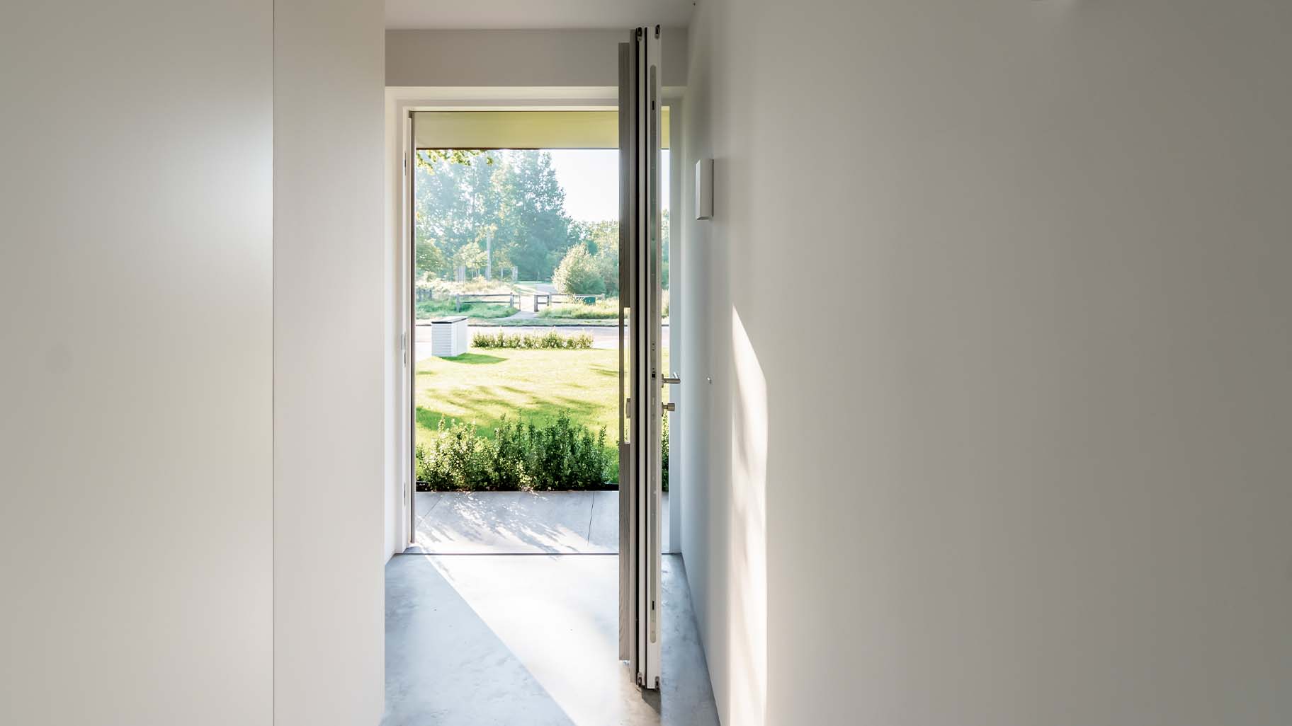 De taatsdeur als voordeur is gelijk met de gevel geplaatst waardoor deze volledig opgaat in het geheel