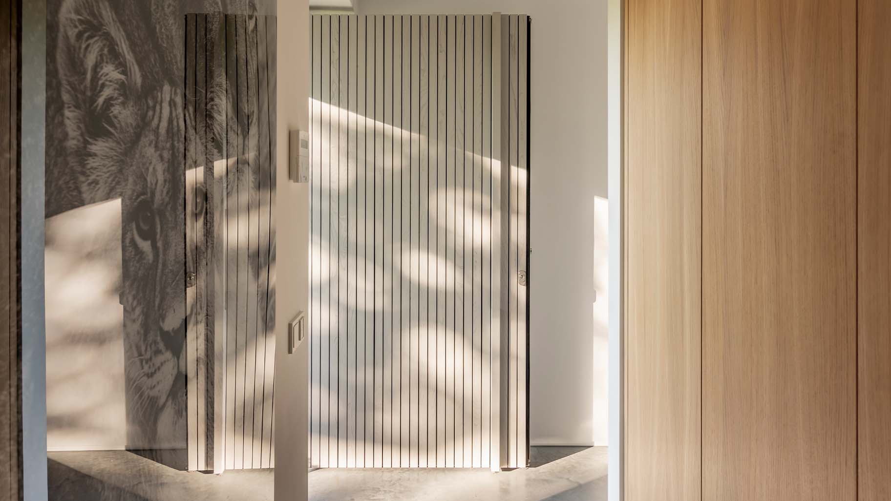 De taatsdeur als voordeur is gelijk met de gevel geplaatst waardoor deze volledig opgaat in het geheel