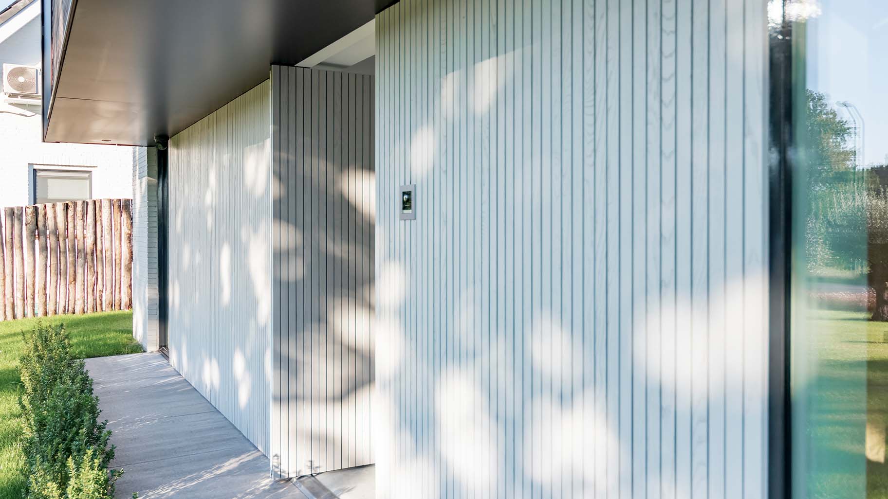 Woning met een houten taatsdeur als voordeur en een houten garagedeur