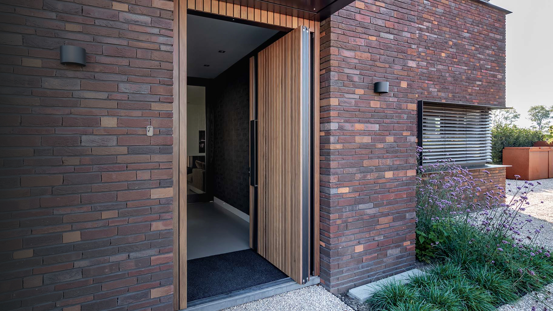 Taatsdeur als voordeur met hout bekleed en zwarte greep