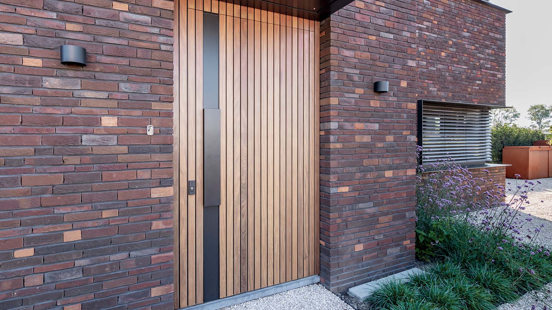 Taatsdeur als voordeur met hout bekleed en zwarte greep