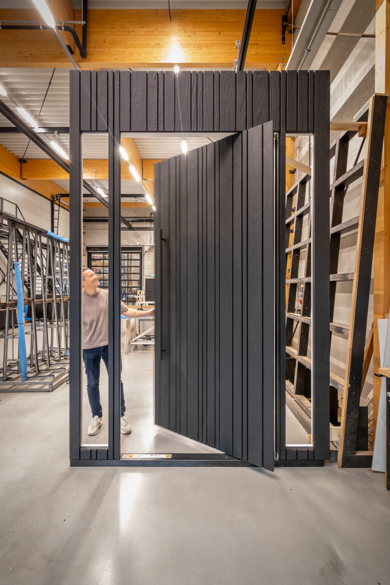 Exclusieve houten taatsdeur van Shou Sugi Ban hout, samen met zijlichten, gemaakt in moderne productiehal in Budel