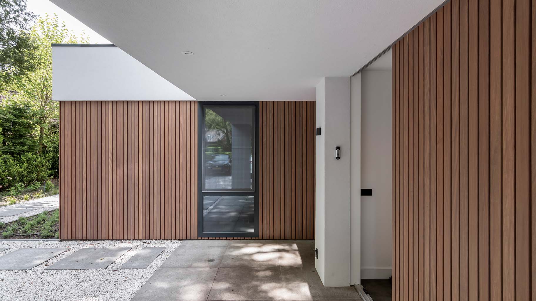 Houten zijwaartse garagedeur bij jaren '30 woning