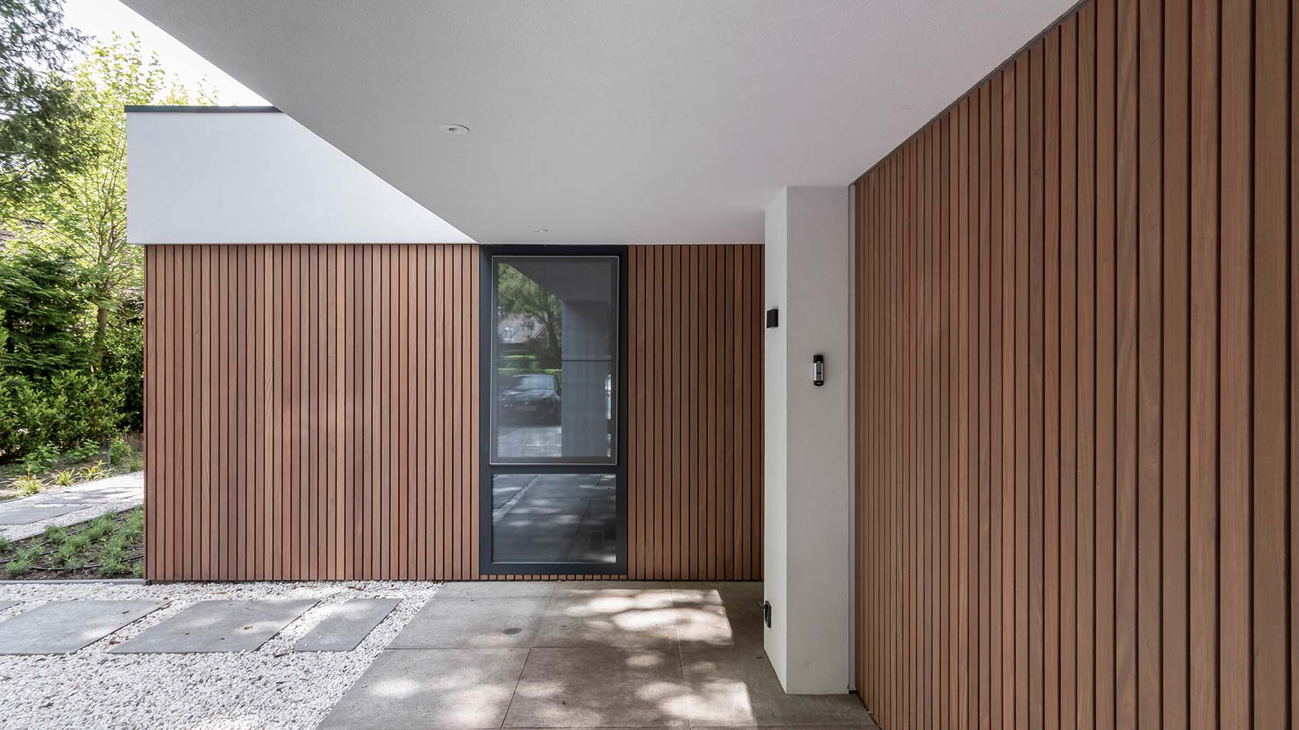 Houten zijwaartse garagedeur bij jaren '30 woning