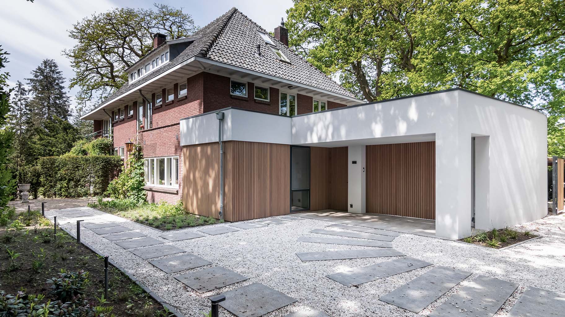 Houten zijwaartse garagedeur bij jaren '30 woning