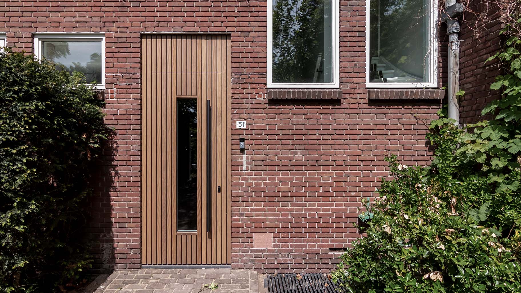 Houten voorgaragedeur bij jaren '30 woning