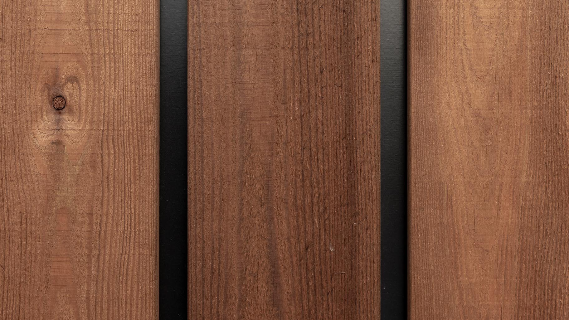 Verticale houten garagedeur geïntegreerd in de gevel, met natuurlijke houttinten