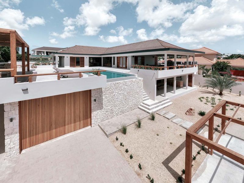 Houten taatsdeur als voordeur en sectionaaldeur voor op Curacao ter entree