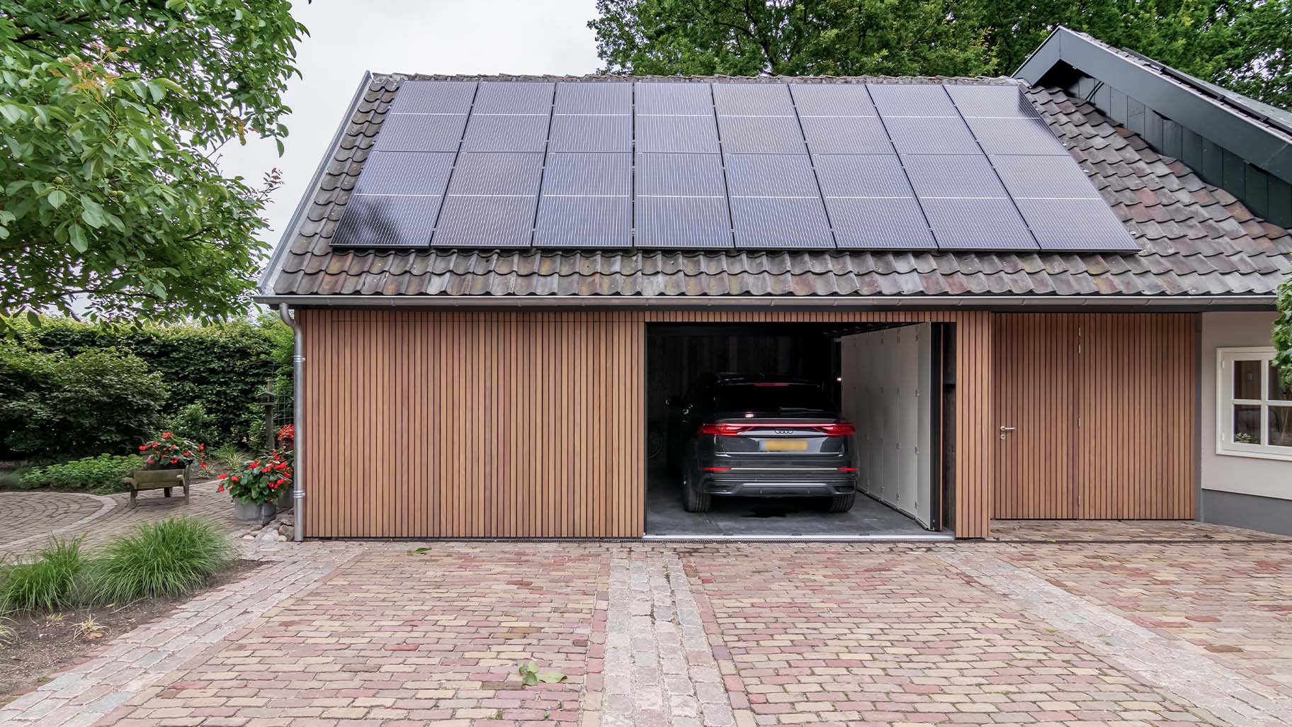 Dubbele zijwaartse houten garagedeur met auto's in de garage