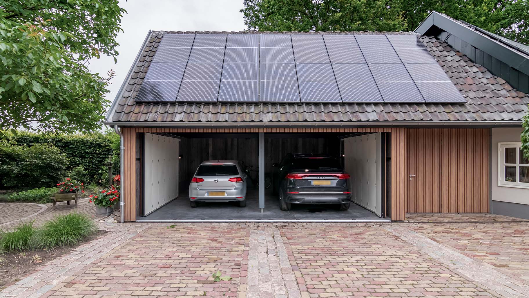Dubbele zijwaartse houten garagedeur met auto's in de garage