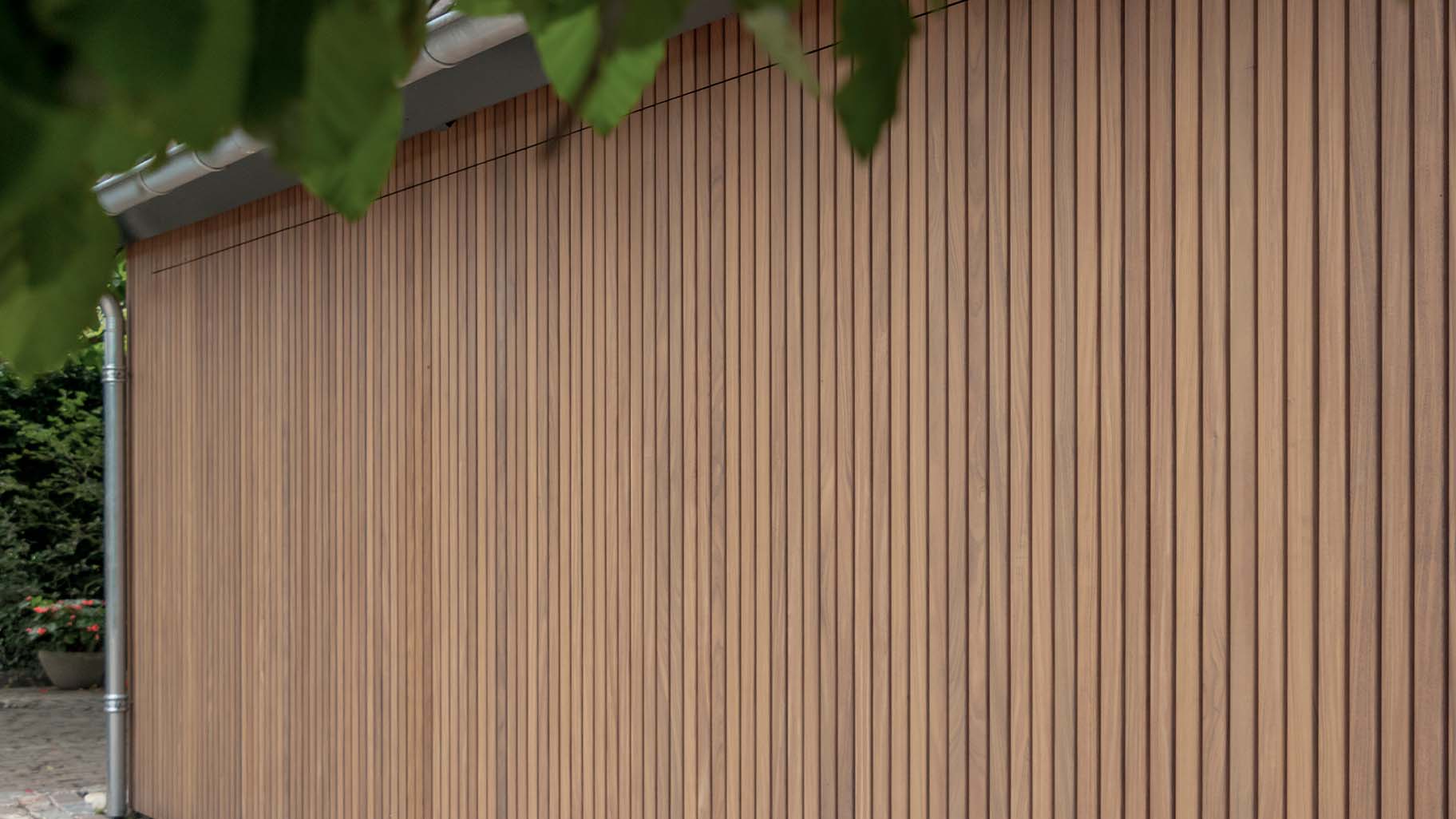 Dubbele zijwaartse houten garagedeur met auto's in de garage