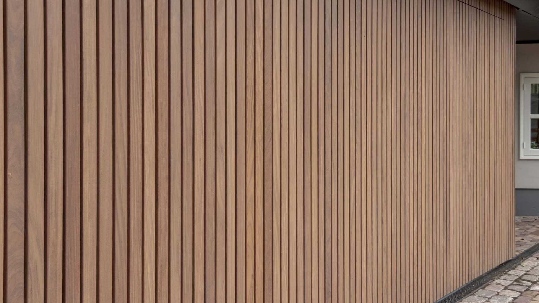 Dubbele zijwaartse houten garagedeur met auto's in de garage