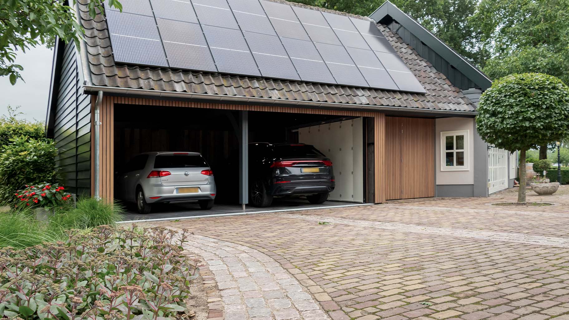 Zijwaartse houten garagedeur bij boerderij woning