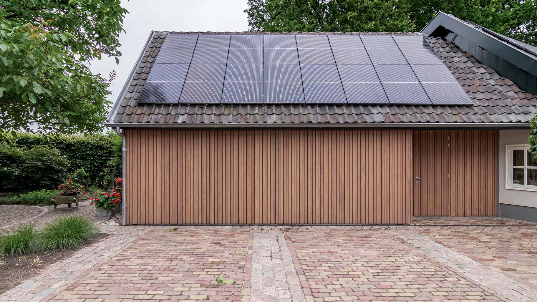 Dubbele zijwaartse houten garagedeur met auto's in de garageDubbele zijwaartse houten garagedeur met auto's in de garage