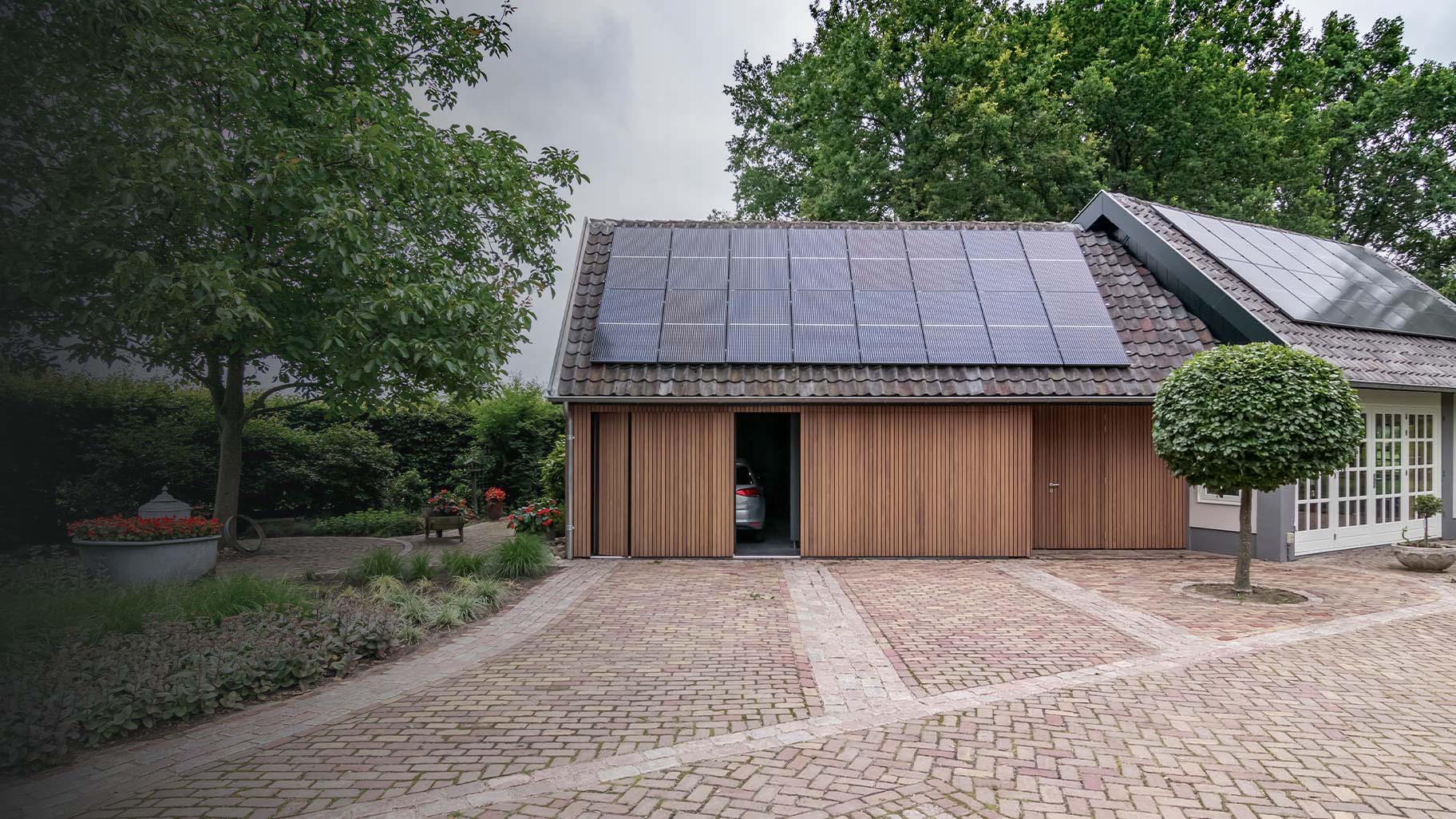 Dubbele zijwaartse houten garagedeur met auto's in de garage