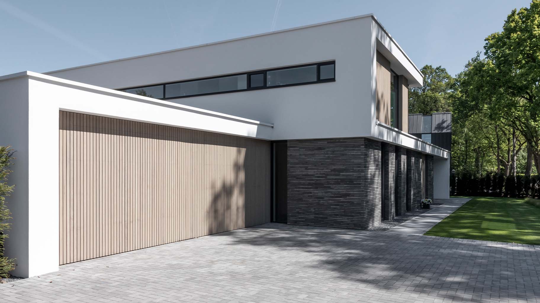 Moderne villa met twee frake houten garagedeuren die naar boven openen