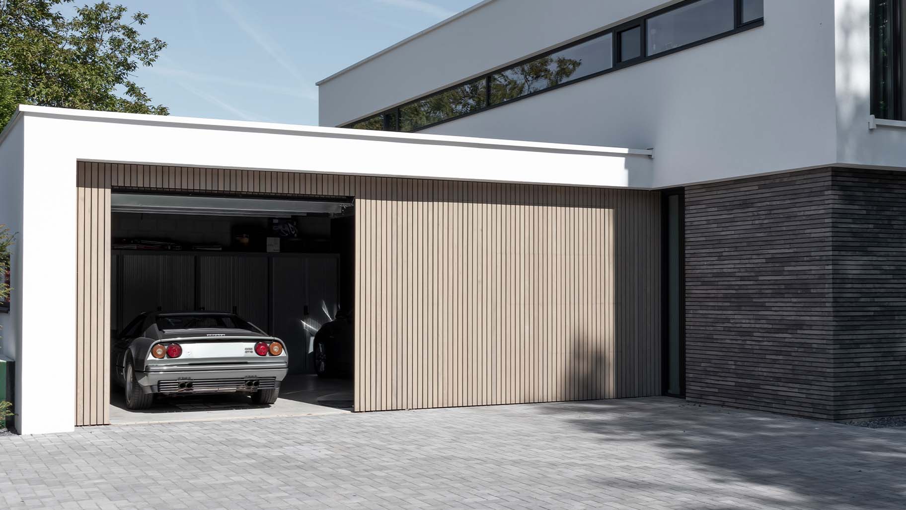 Moderne villa met twee frake houten garagedeuren die naar boven openen