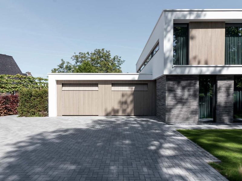 Moderne villa met twee frake houten garagedeuren in de garage