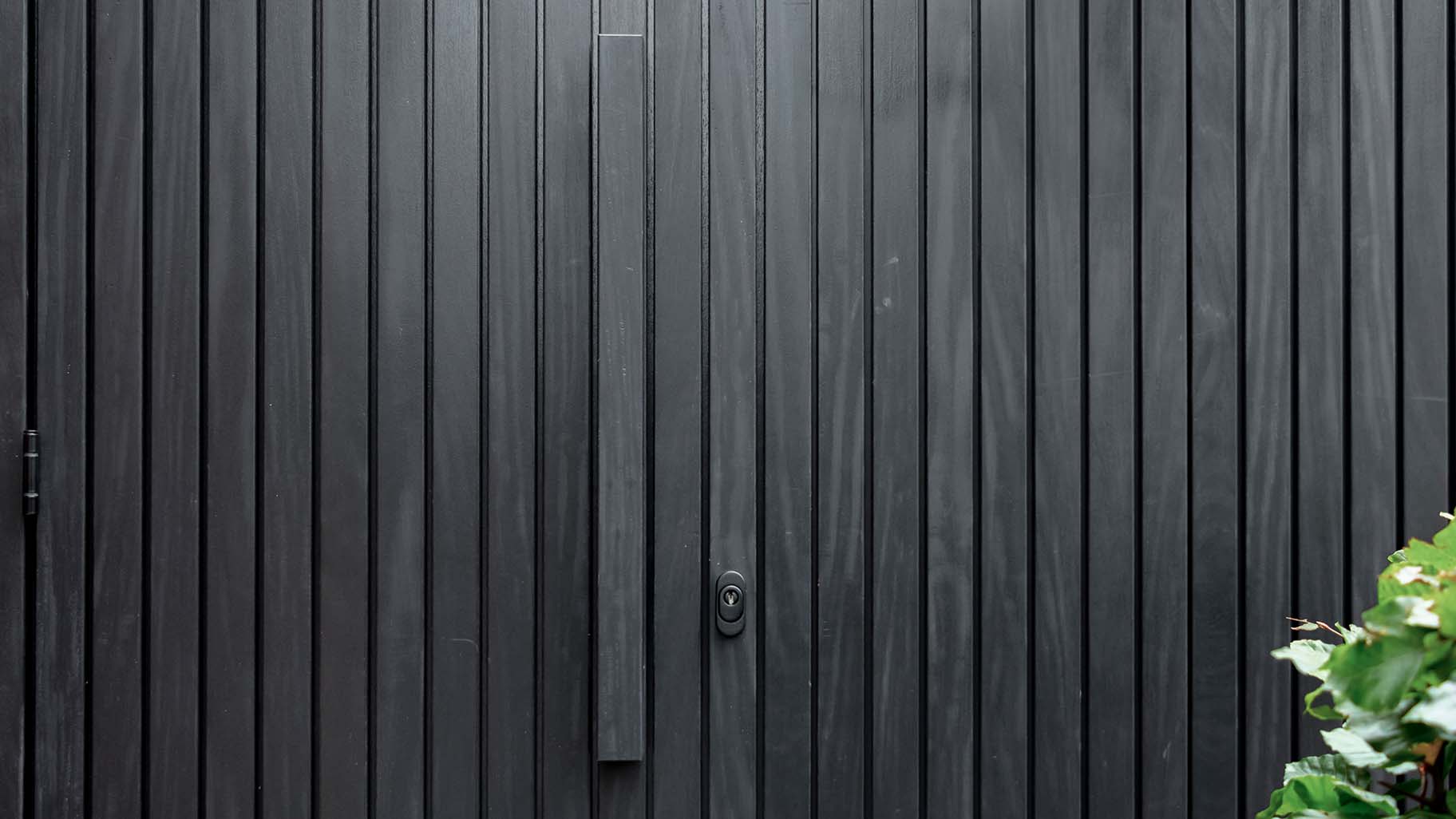 zwarte Afrormosia houten garagedeur met verticale latten