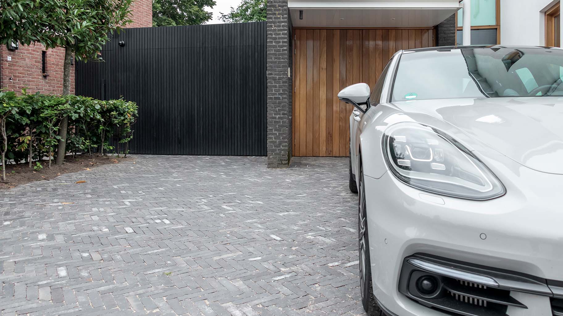 Op maat gemaakte zwarte houten zijwaartse garagedeur, gerealiseerd door Different Doors