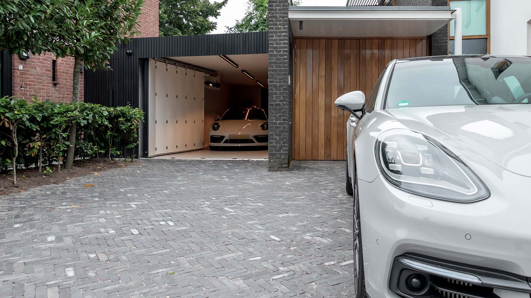 Op maat gemaakte zwarte houten zijwaartse garagedeur, gerealiseerd door Different Doors